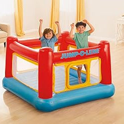 Children playing inside an inflatable bouncy in a living room.