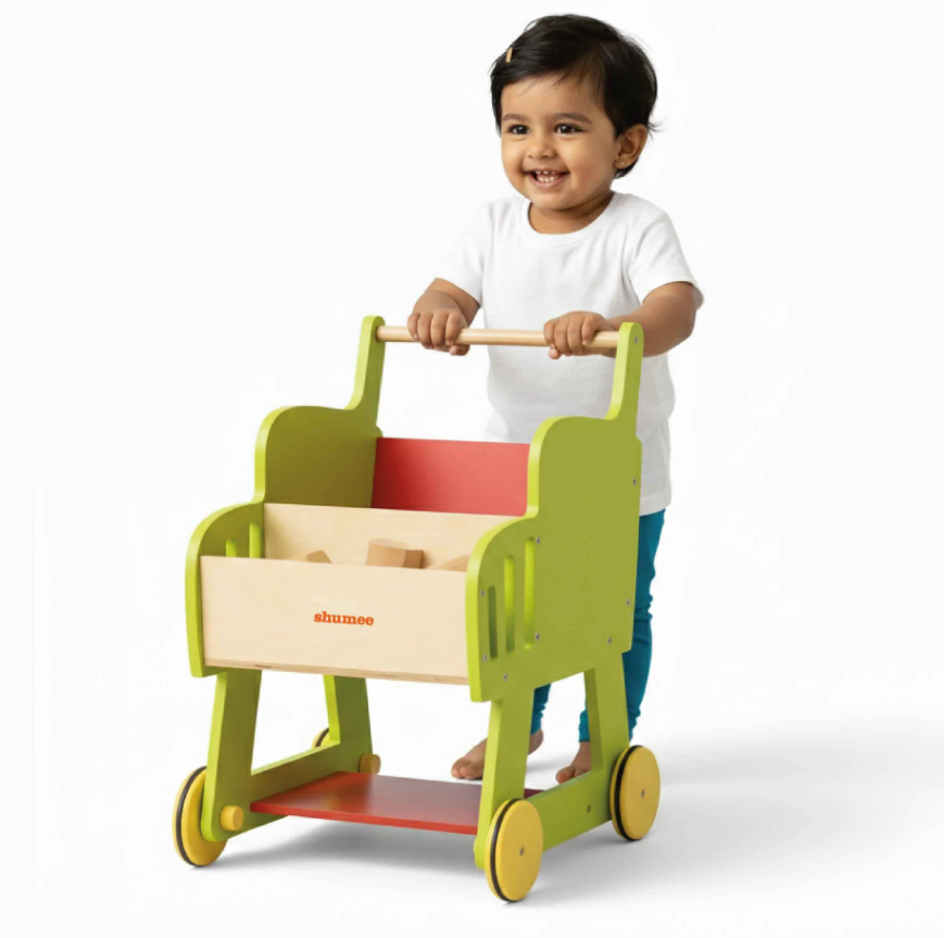 Child pushing a colorful toy cart with a white background