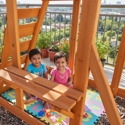 Wooden swing set on a mulched ground with grass and plants in the background