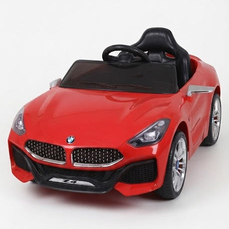 A red BMW-style children's ride-on toy car with a black steering wheel and black windshield, photographed on a clean white studio background.